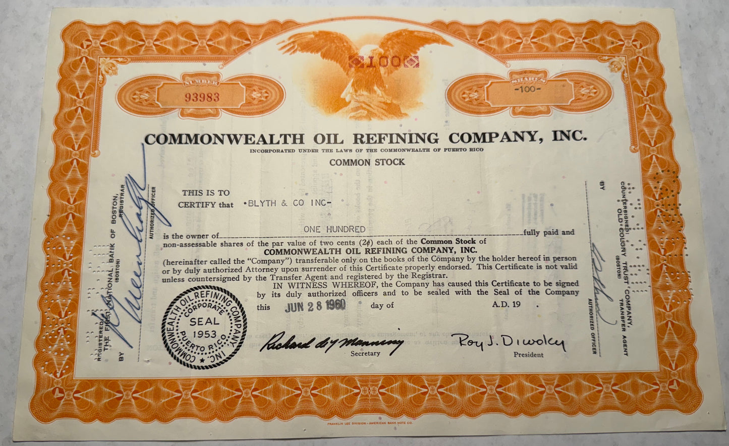 This orange stock certificate from Commonwealth Oil Refining Company, issued in 1960, features a vignette of a bald eagle, symbolizing strength and freedom. The certificate includes cancellation holes, stamps, and handwritten annotations, marking its authenticity and previous transactions.