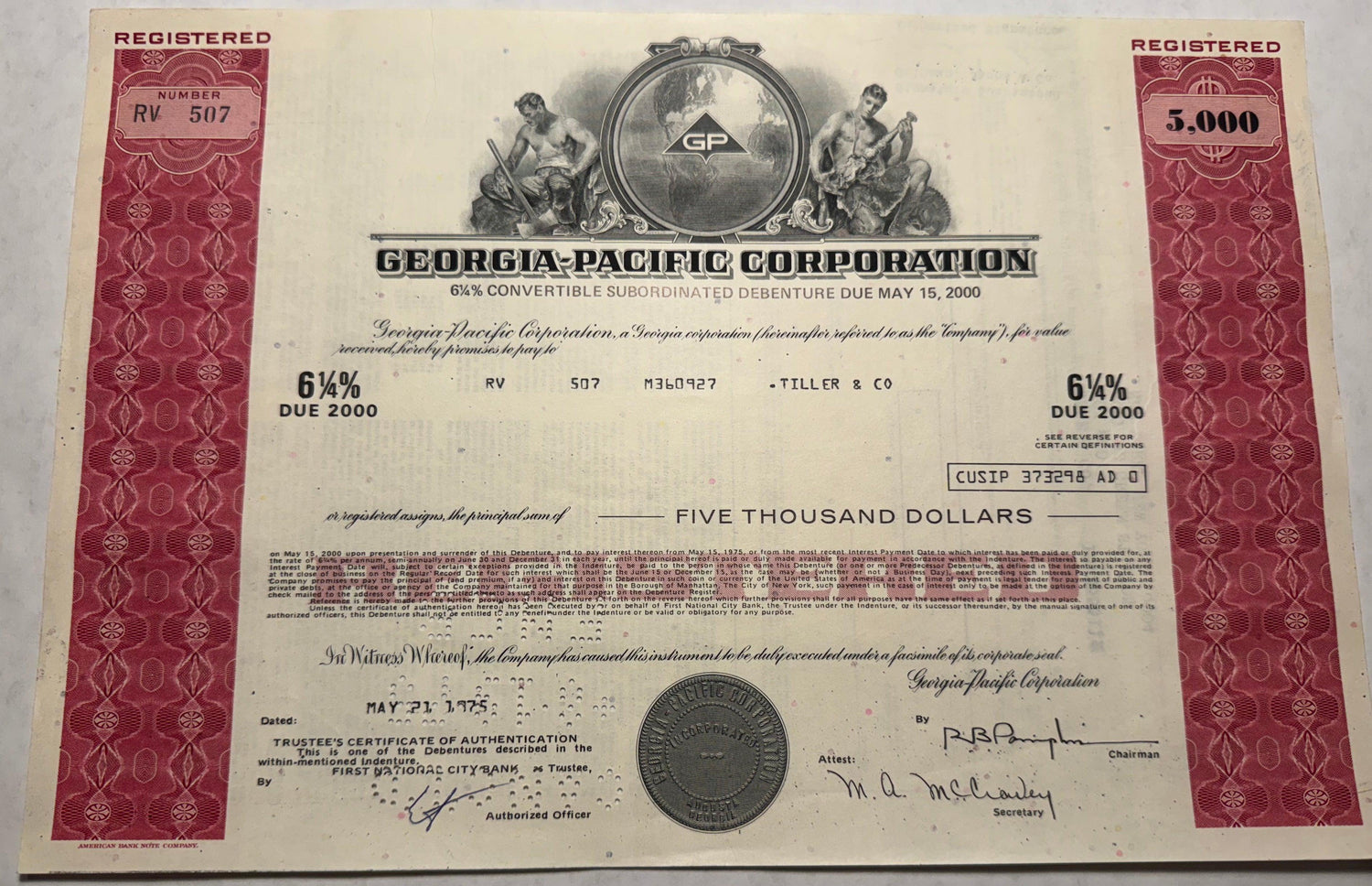 This is a red bond certificate from Georgia Pacific Corporation, issued in 1975. It features a vignette of two men working.