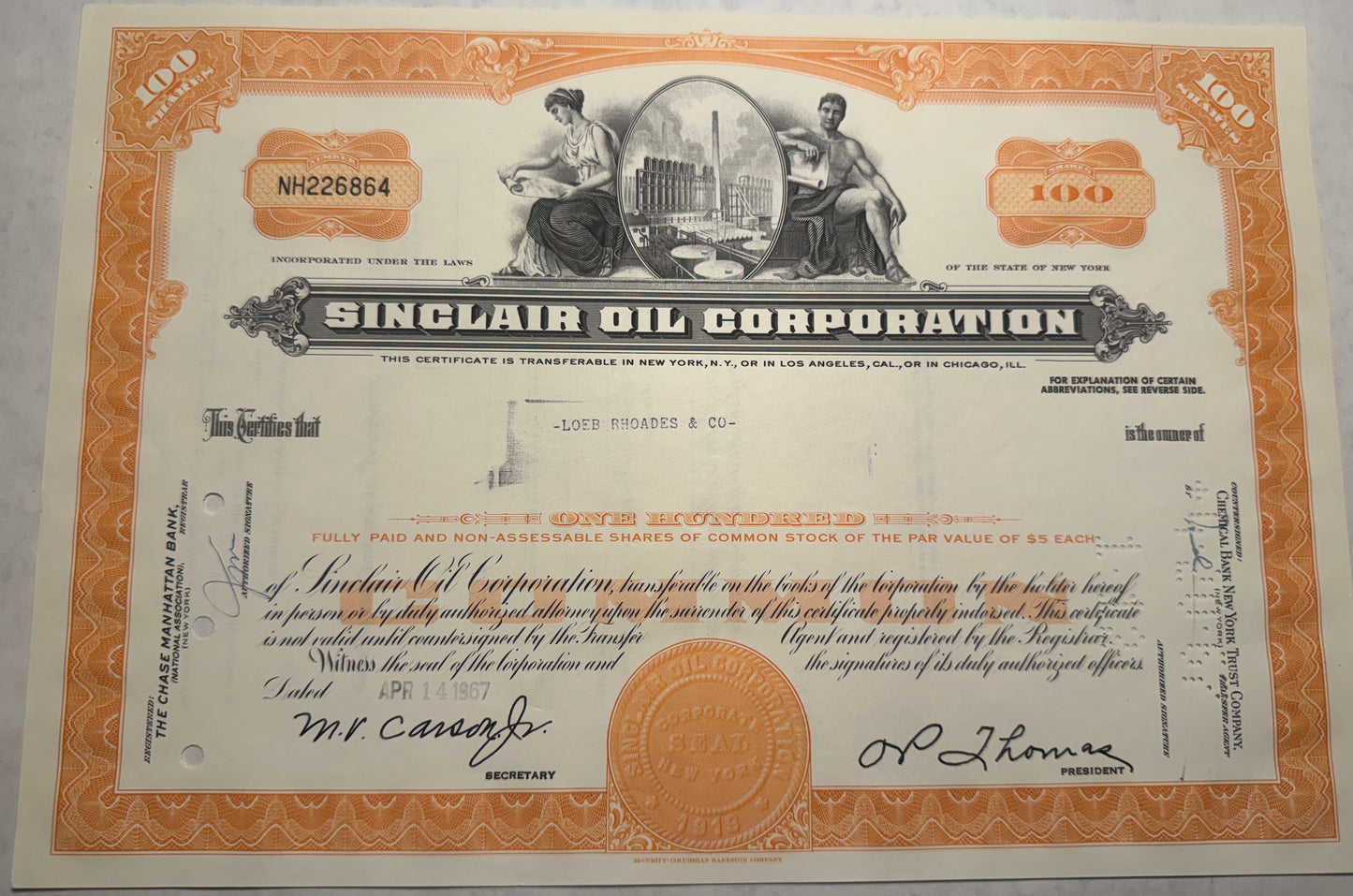  This orange stock certificate from Sinclair Oil Corporation, issued in 1967, features cancellation holes, stamps, and handwriting, reflecting its authenticity and historical use.