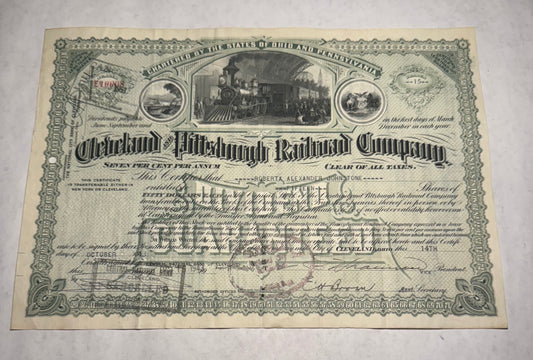 This green stock certificate from the Cleveland and Pittsburgh Railroad, issued in 1943, features a vignette of a steam train at the station loading passengers.